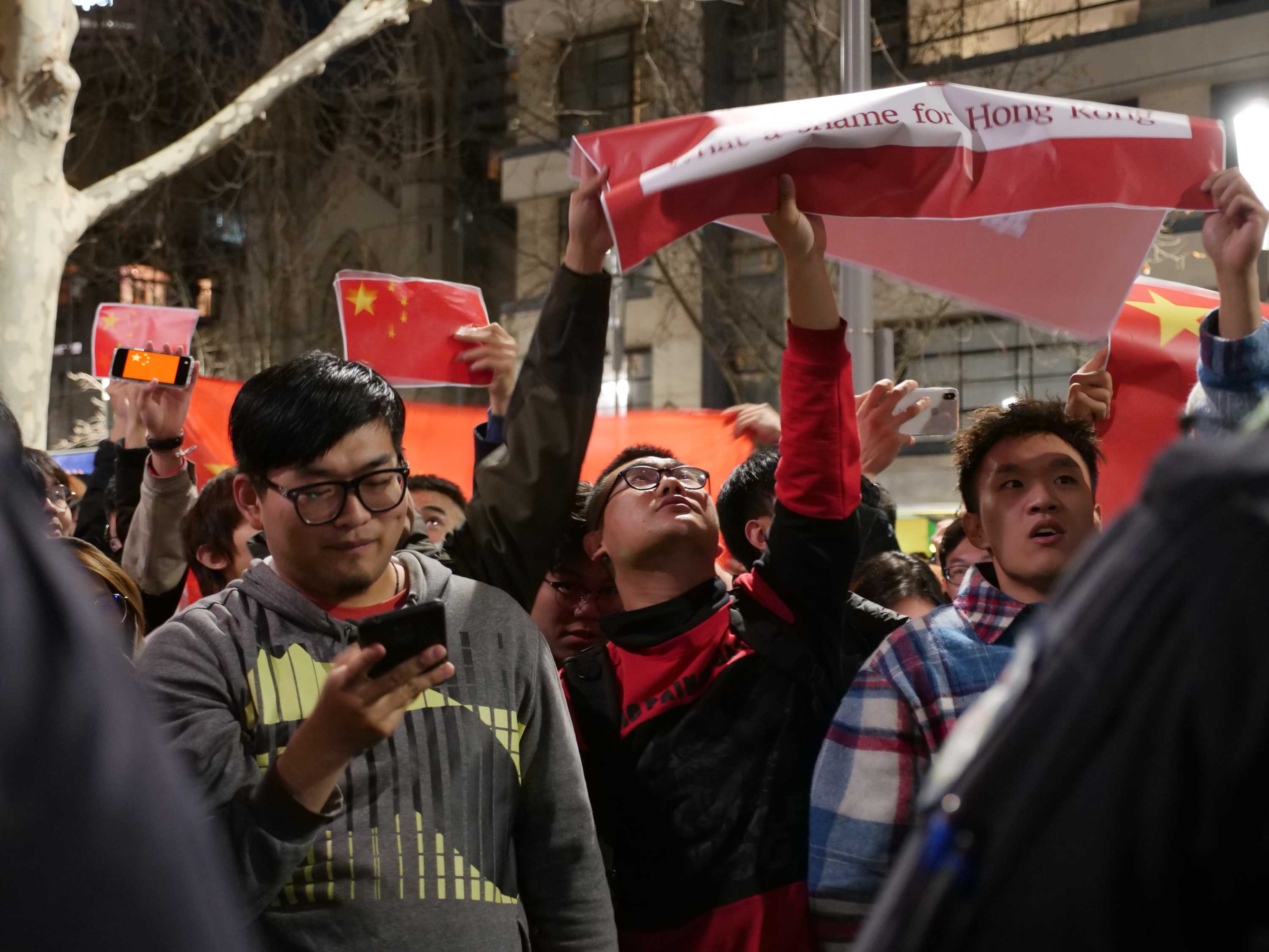 支持中国政府的示威者在墨尔本一场游行中举着中国国旗
